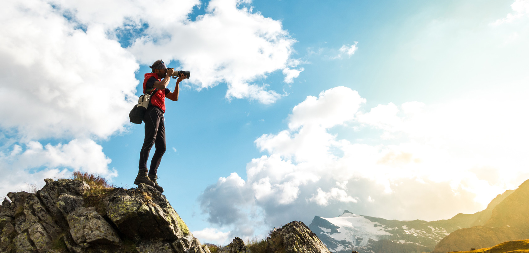 Photographer shoots a yellow sun set on a mountain and considers photographers professional liability insurance